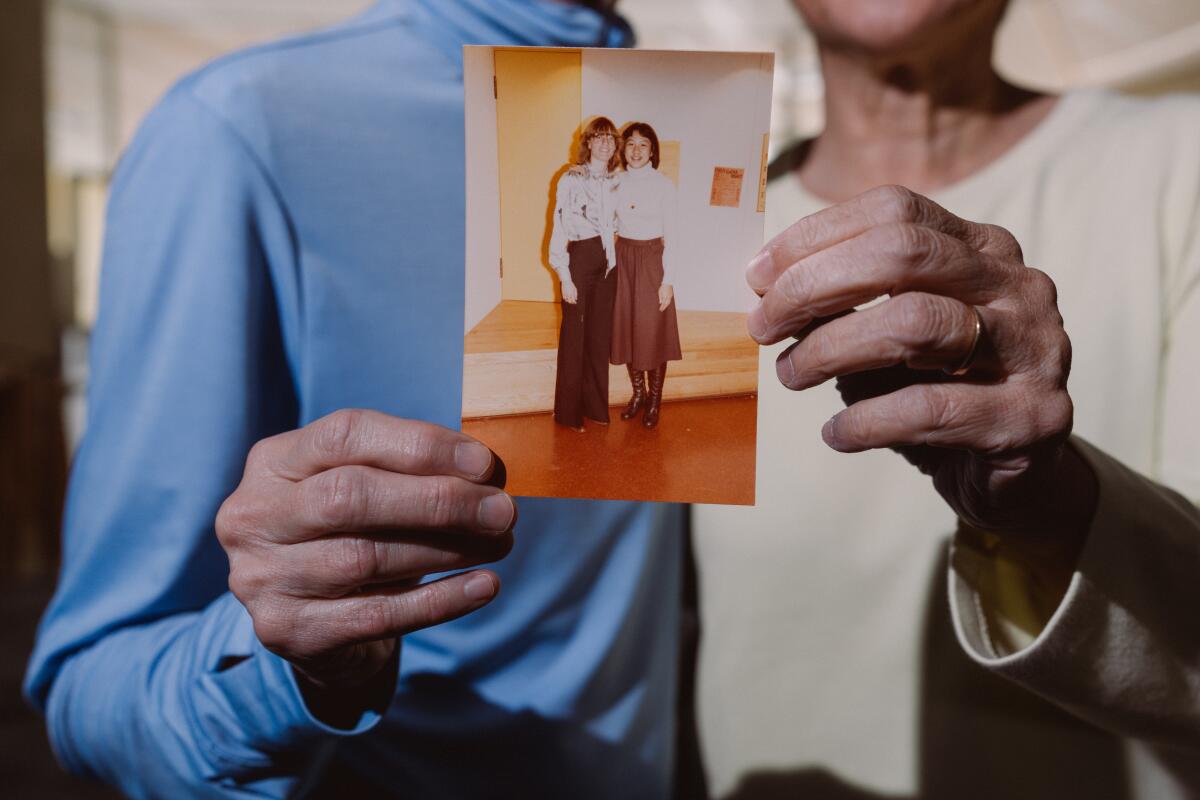 Davi and Bracha hold an old photo of them from their college years at the University of California, Berkeley.