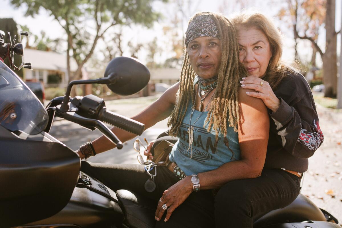 Gevin Fax (left) and Cathy Tangum pose for a portrait on Gevin's motorcycle in front of their home in Van Nuys, Calif.