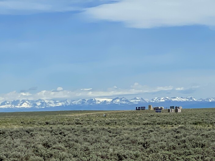 Natural gas infrastructure with snowy mountains in the distance.