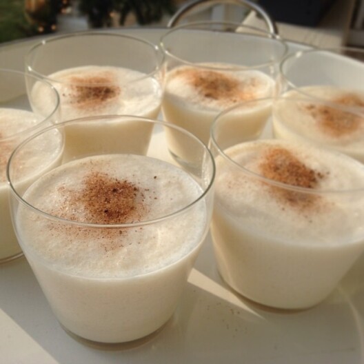 Cups of eggnog with nutmeg on top.
