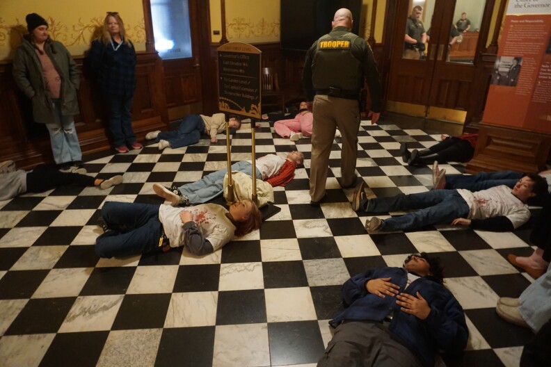 Protestors, including students at the University of Wyoming, staged a "die-in" outside the governor's office to urge him not to sign HB 172.