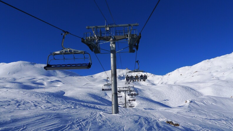 A ski lift goes up a snowy mountain.