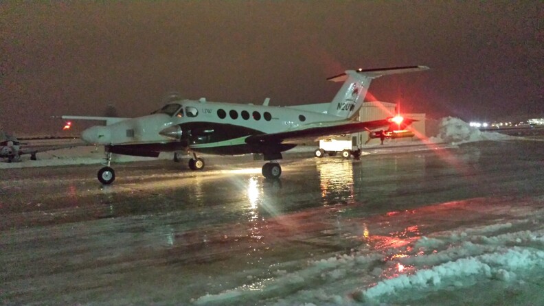 A plane on an icy runway at night.
