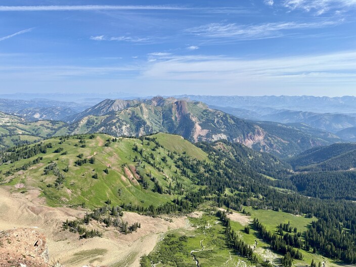 Grass covered mountains on a blue sky day.