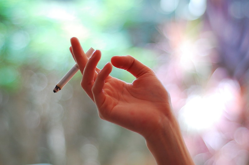 hand smoking cigarette holding and smoke on black Stock Photo E-Cigs and Second-Hand Vaping: Dangers