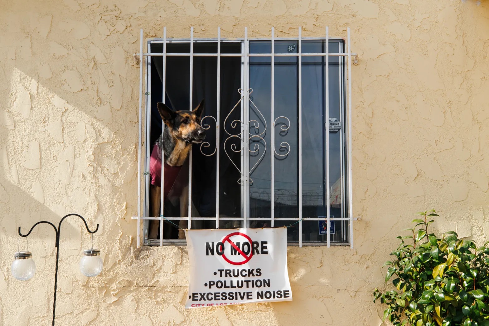 A sign under Jose Ulloa’s window in Wilmington protests the truck traffic.