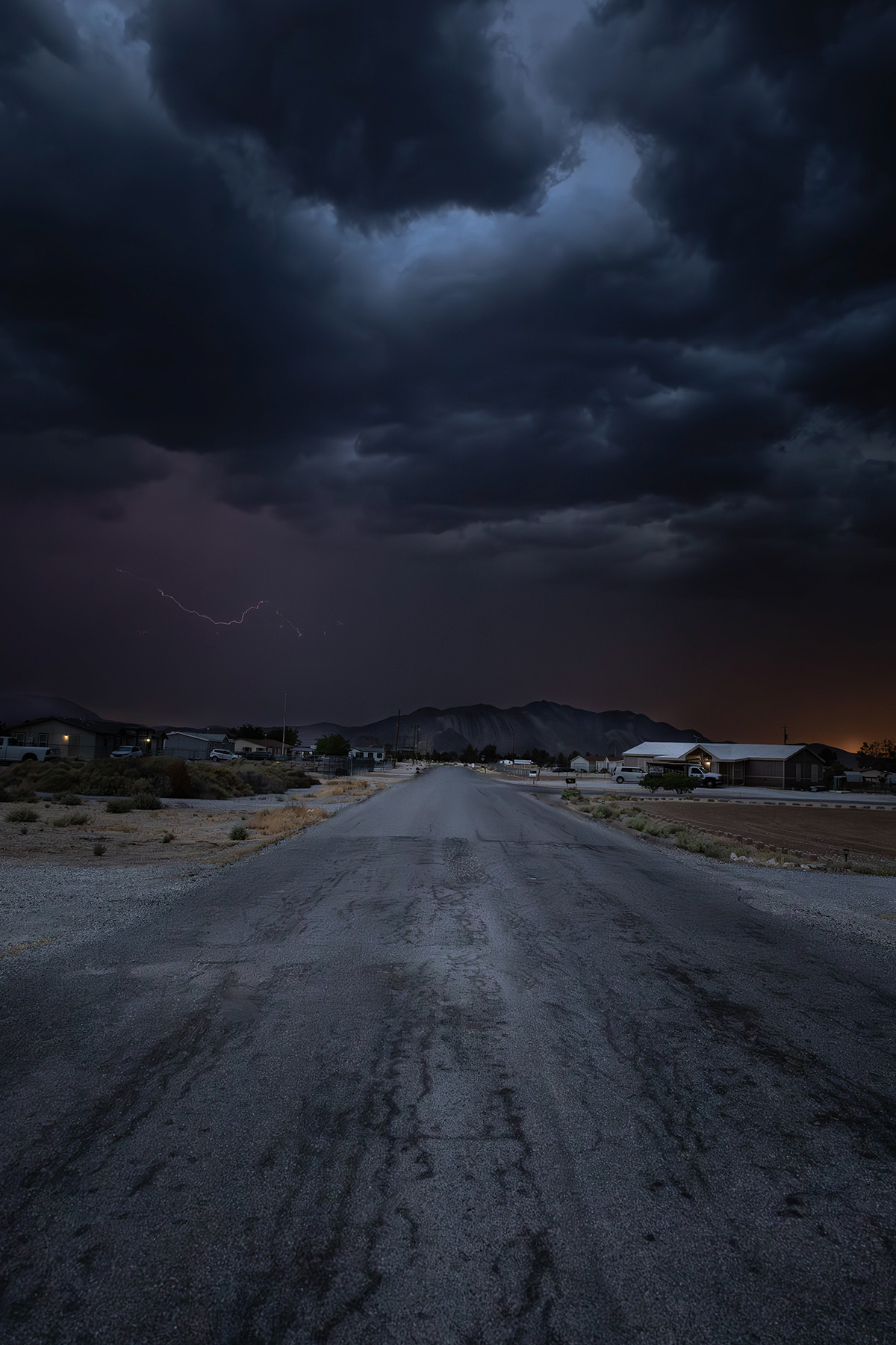 Rainy Pahrump road stretching into the distance at sunset.