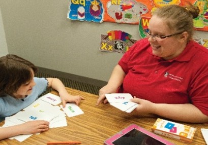Tutor and student working with word cards at a table