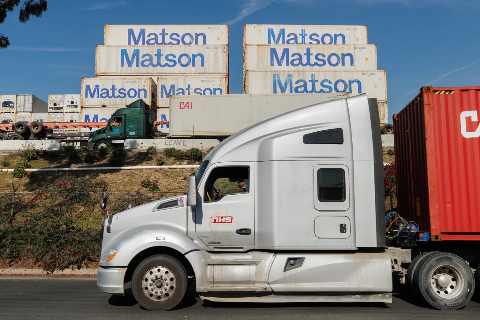 Diesel trucks carrying cargo to and from the Port of Los Angeles pass by a warehouse in the Wilmington area. Diesel exhaust is a main source of smog and soot in the region.