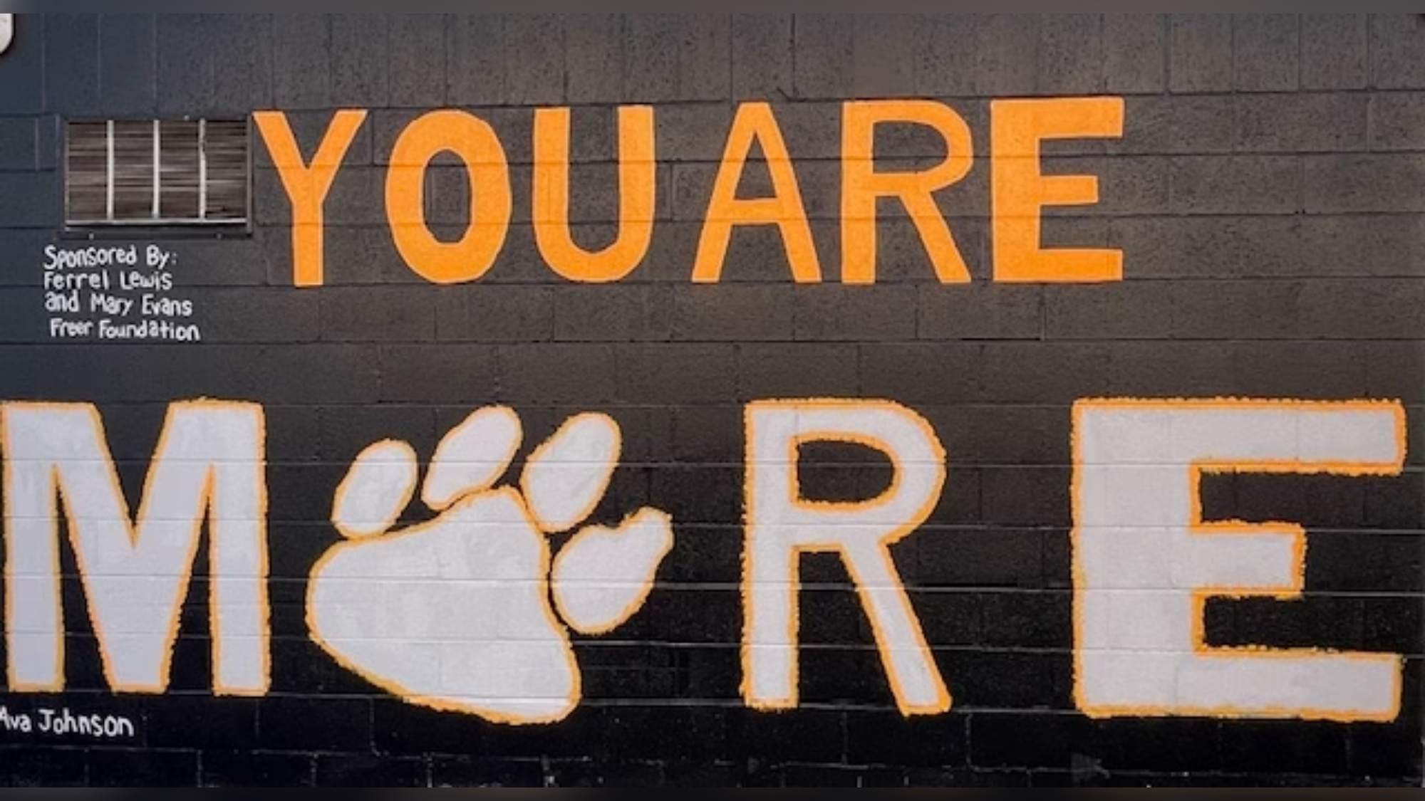 A painted mural that says you are more and the o in more is a pawprint.