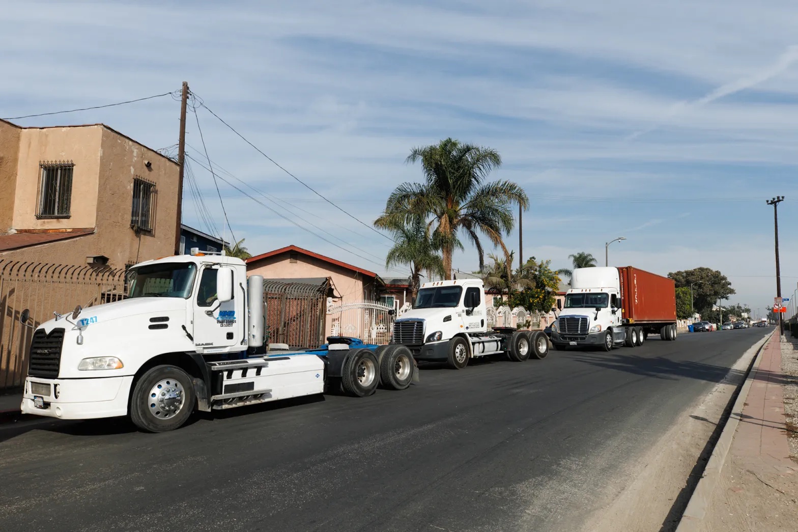 Diesel trucks pass in front of homes on Drumm Avenue in Wilmington.