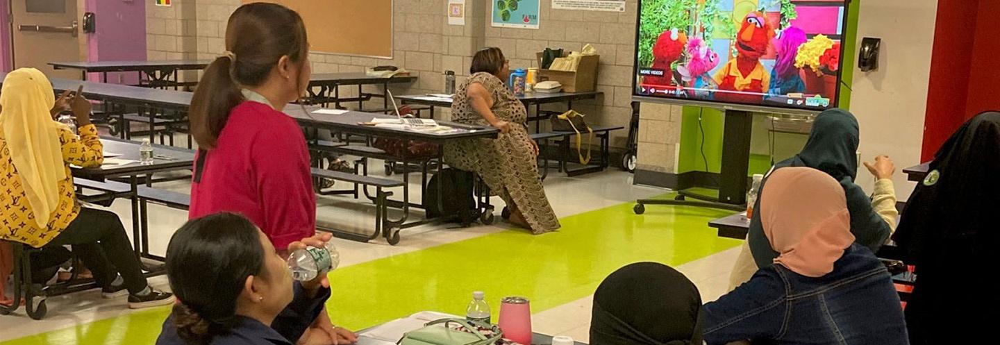 children watching Sesame Street in a cafeteria