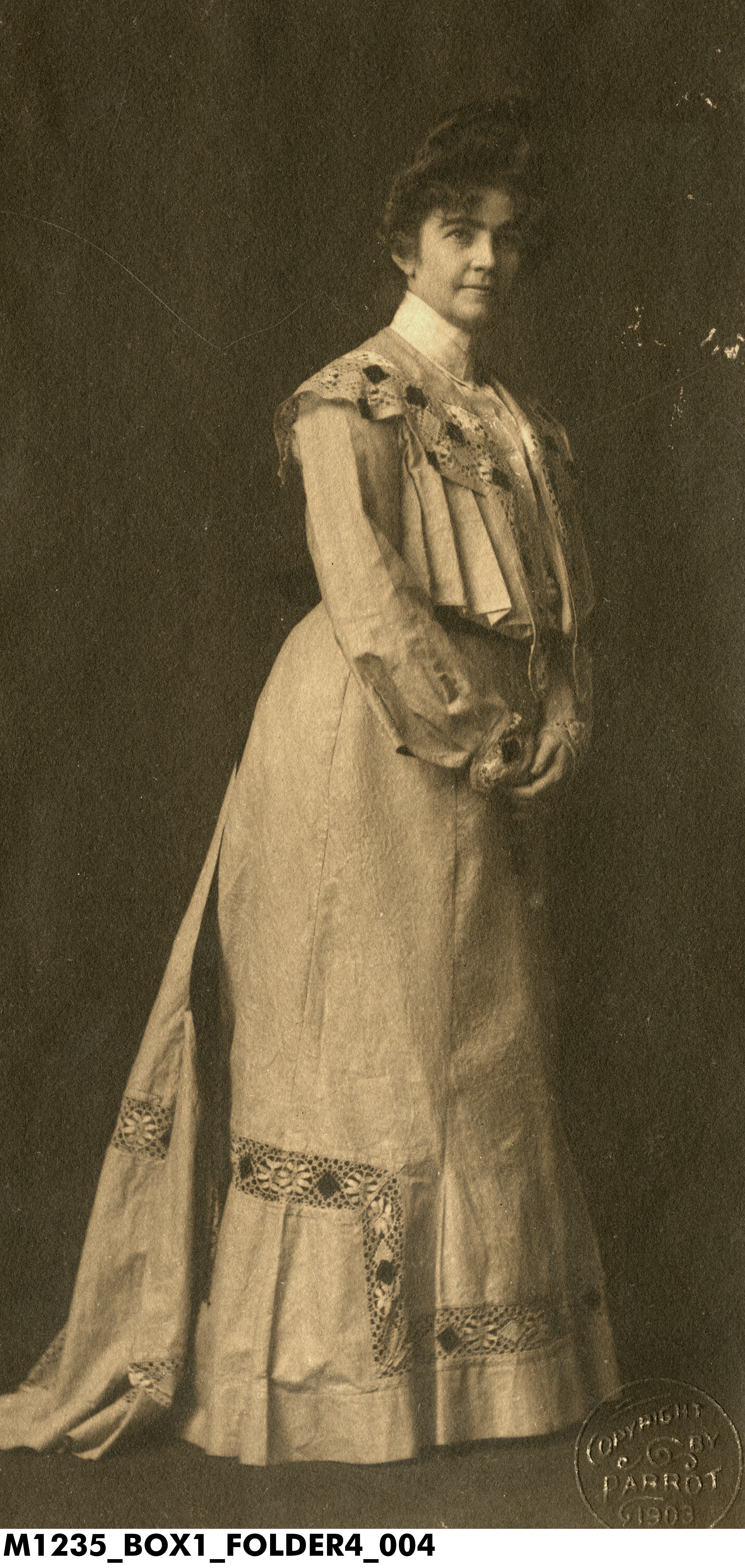 Full-length portrait of author and naturalist Gene Stratton-Porter from 1903, standing in profile while facing forward, wearing a formal, floor-length light-colored dress.