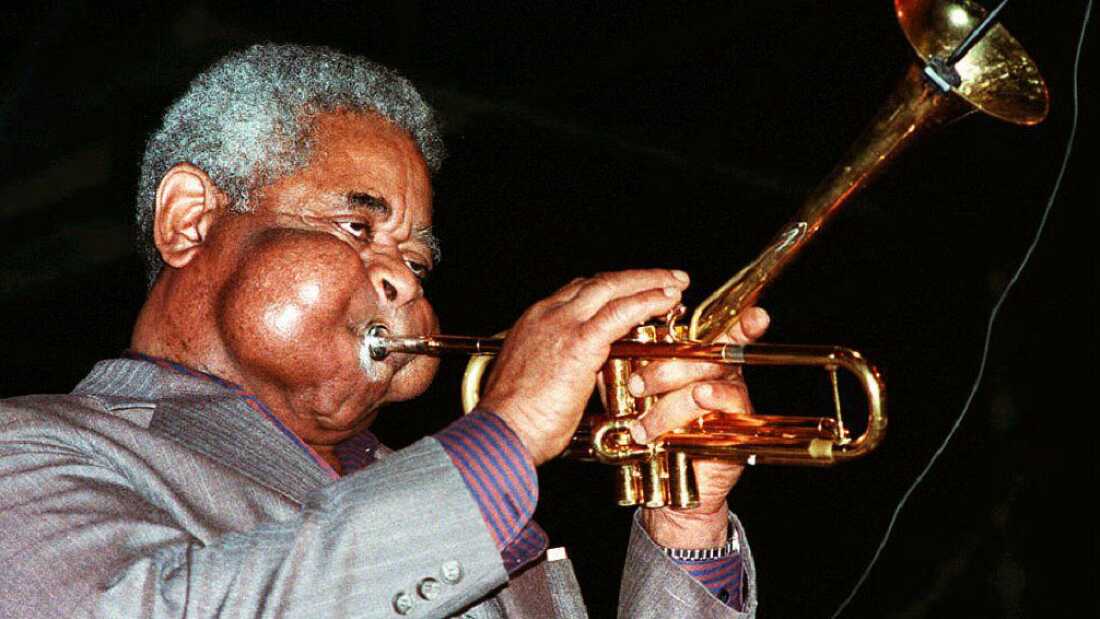 The late jazz legend Dizzie Gillespie plays a trumpet with his iconic puffed cheeks.
