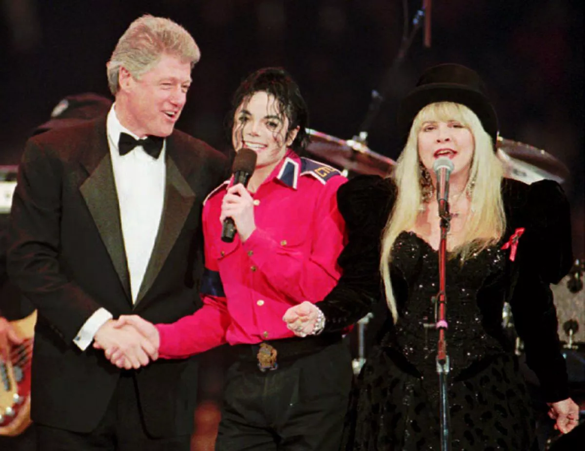 President Bill Clinton (left) shakes hands with Michael Jackson (center) as Stevie Nicks sings during inauguration festivities in Landover, Md.