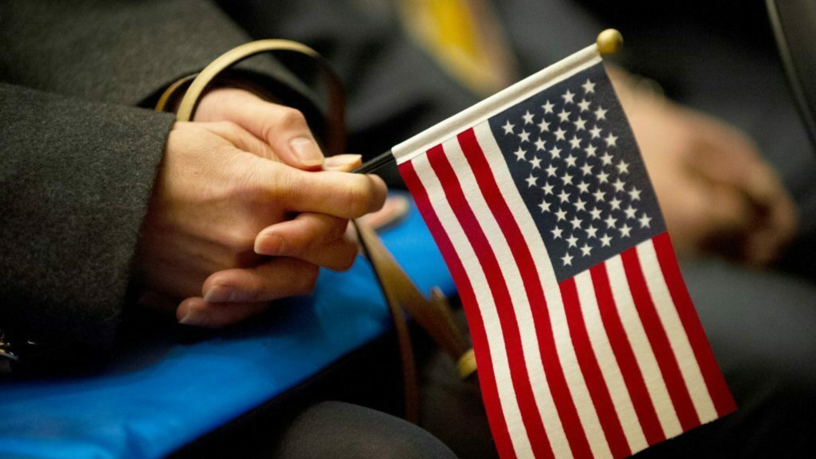 A woman holds an American flag during a naturalization ceremony.