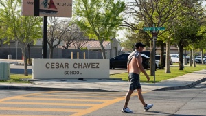 A man walks March 19 past Cesar Chavez Elementary School in Bakersfield, Calif.