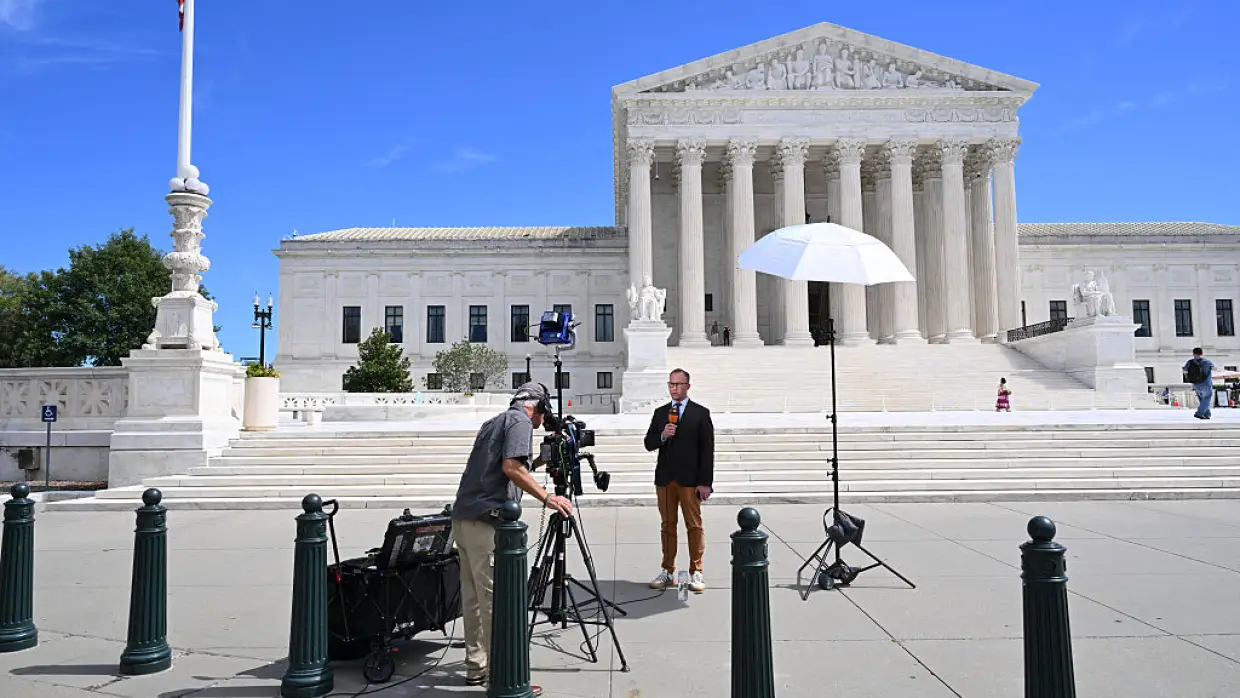 Broadcast journalists work in front of the U.S. Supreme Court in Washington, D.C., on Sept. 15. The new term begins on Monday.