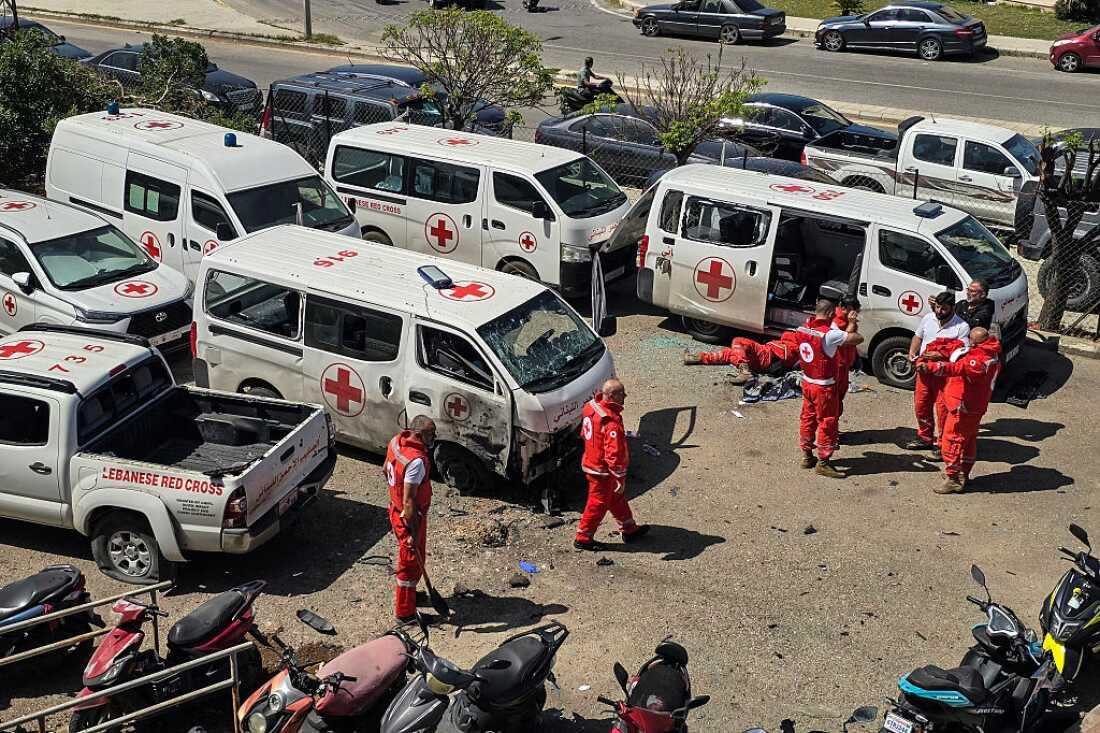 Lebanese Red Cross volunteers inspect the damage to their rescue ambulances at the site of an Israeli drone strike that targeted their headquarters in the southern city of Tyre on April 13, 2026.