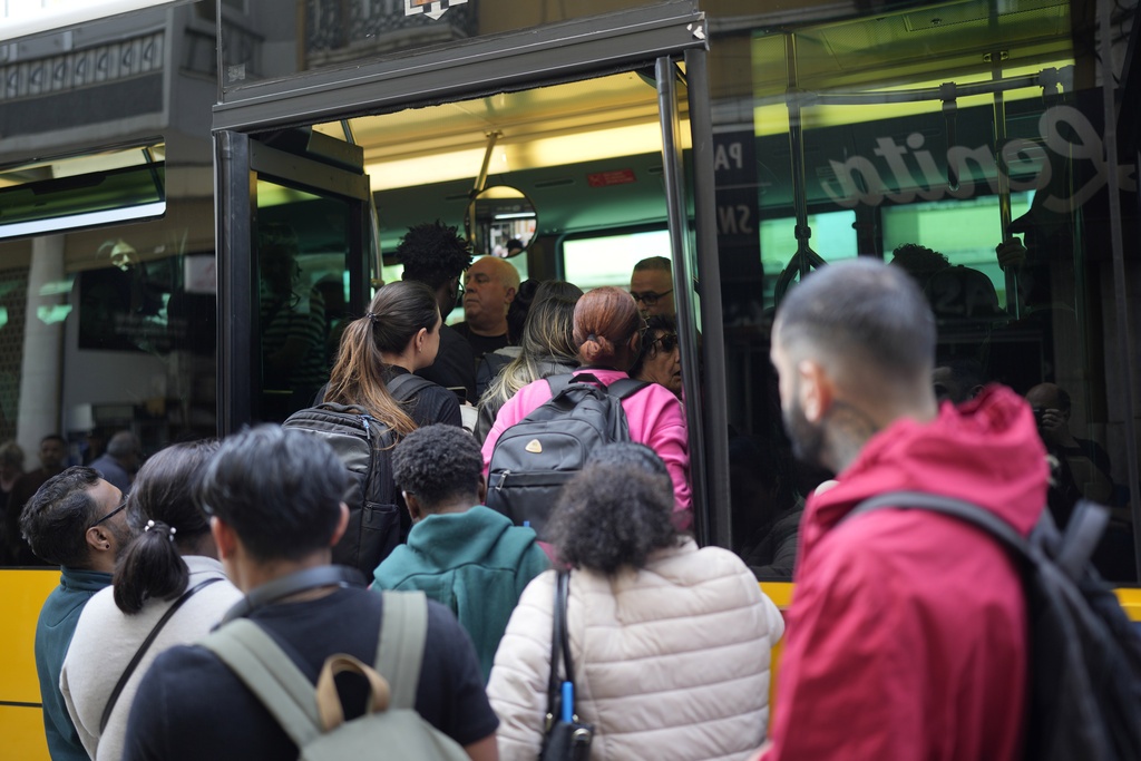 People try to board a crowded bus Monday after the subway stopped running during a power outage in Lisbon, Portugal. (AP Photo/Armando Franca)