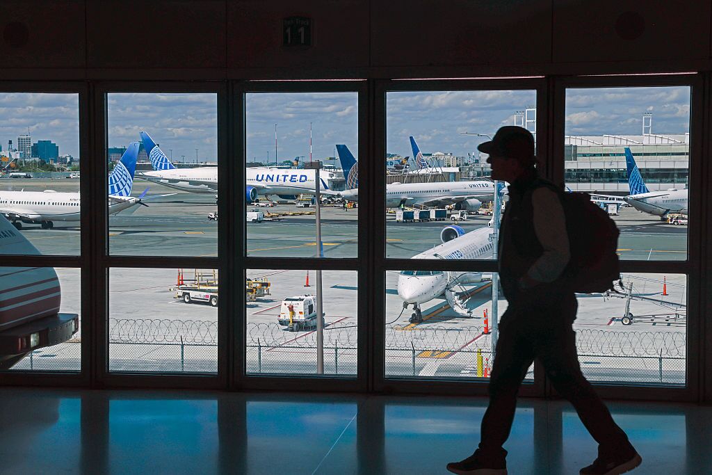 A traveler walks through Newark Liberty International Airport in early June. United Airlines says Newark was the most reliable airport in the New York City area in June — a remarkable turnaround after a wave of cancellations and delays in April and May.