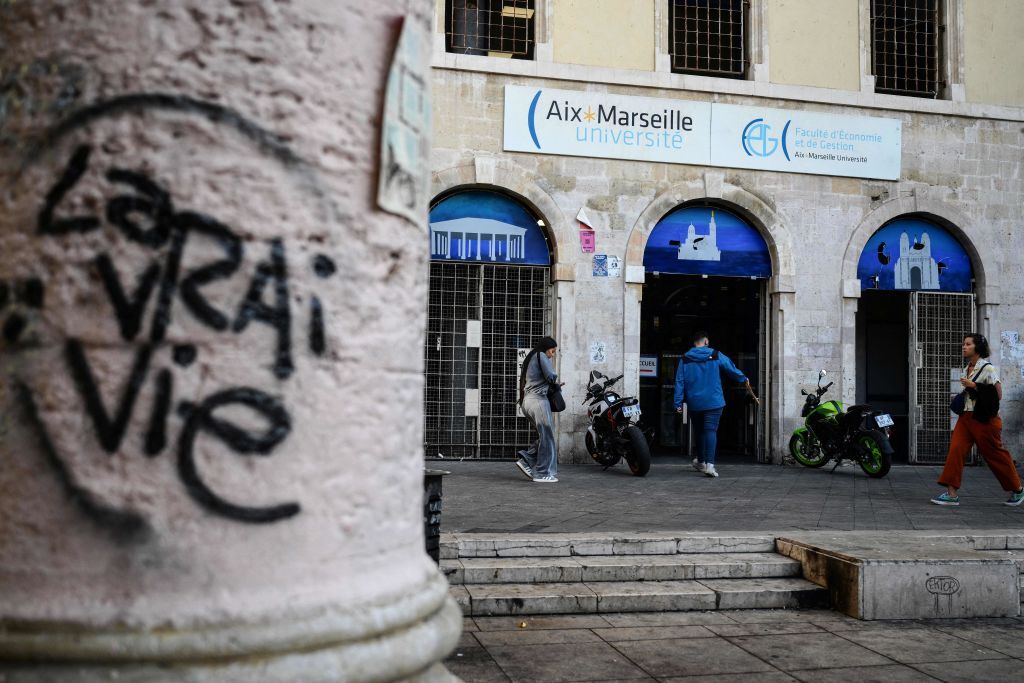 People walk past the faculty of economy of the Aix-Marseille University in Marseille on Oct. 4, 2023.