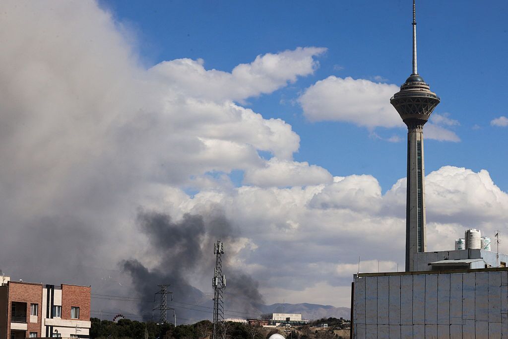 A plume of smoke rises following reported explosions in Tehran on March 1, 2026.