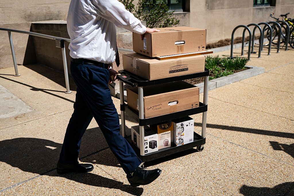 A worker wheels out the belongings of a fellow employee who was dismissed, outside of the Mary E. Switzer Federal Office Building, which houses HHS offices in Washington, D.C., on Tuesday.