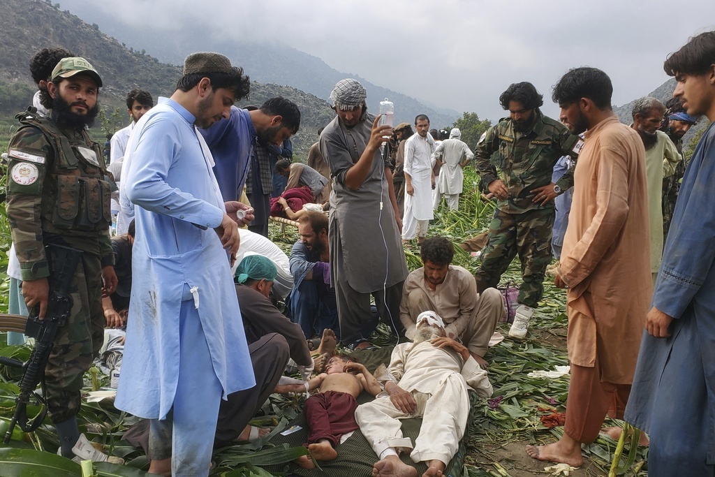 Civil defense workers, locals, and army soldiers prepare Monday to evacuate injured victims of an earthquake that killed hundreds and destroyed numerous villages in eastern Afghanistan, in Mazar Dara, Kunar province.