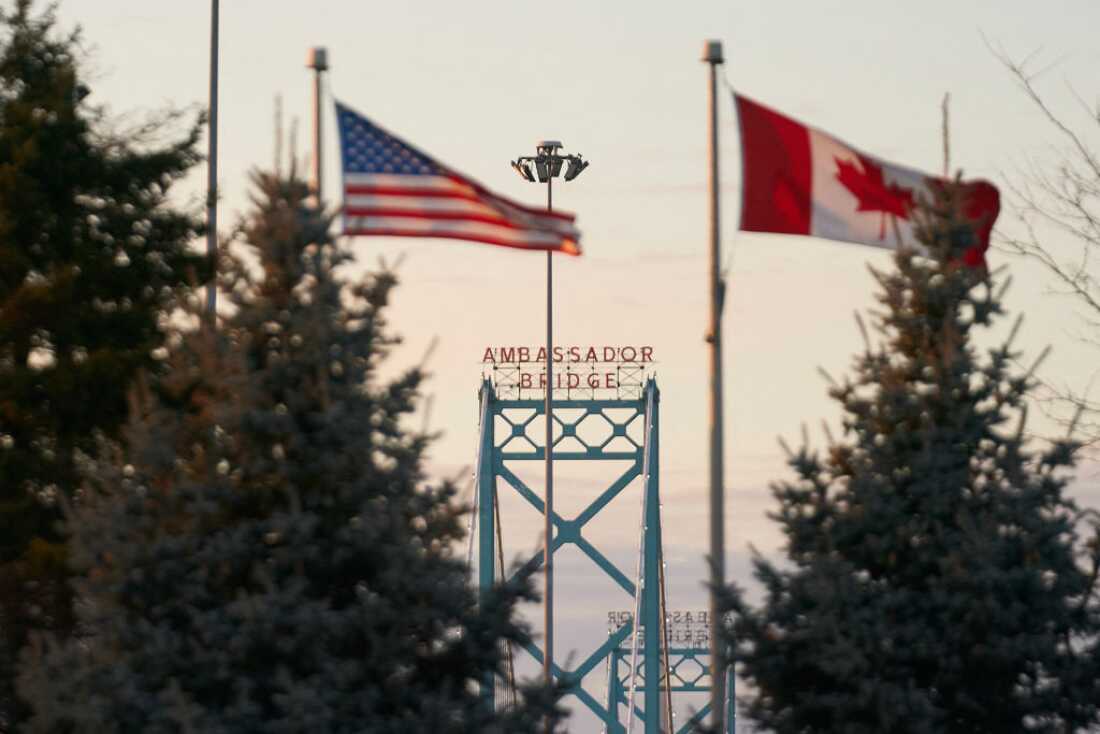 Canadian and American flags fly on the Canadian side of the Ambassador Bridge in Windsor, Ontario, on March 8. President Trump imposed vast tariffs this week on key partners Canada and Mexico, roiling cross-border ties before offering temporary relief to manufacturers -- but with more levies kicking in next week, the respite may be fleeting.