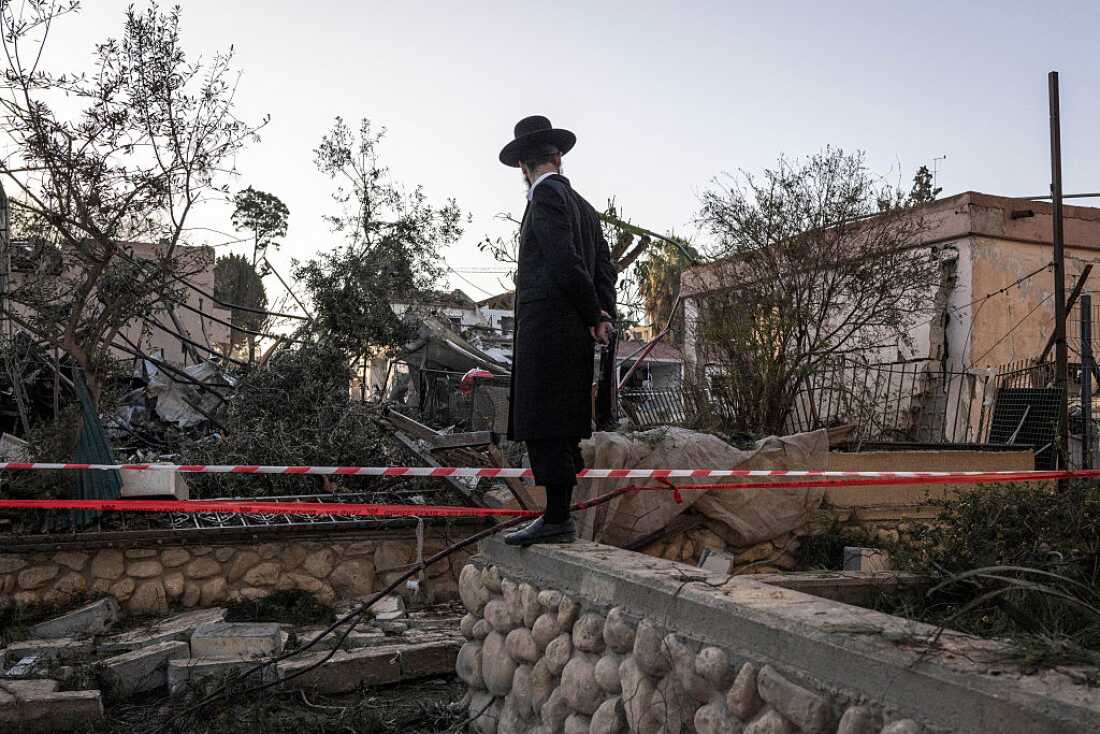 An Ultra-Othodox Jewish man looks at the houses destroyed in an Iranian missile strike in Dimona on March 22, 2026.