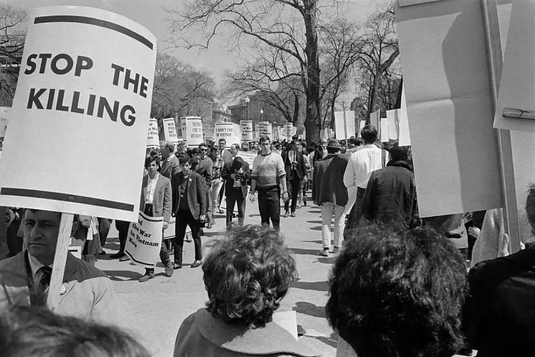 Demonstrators carrying signs against the war in Vietnam march in front of the White House in April 1965 in Washington, D.C.