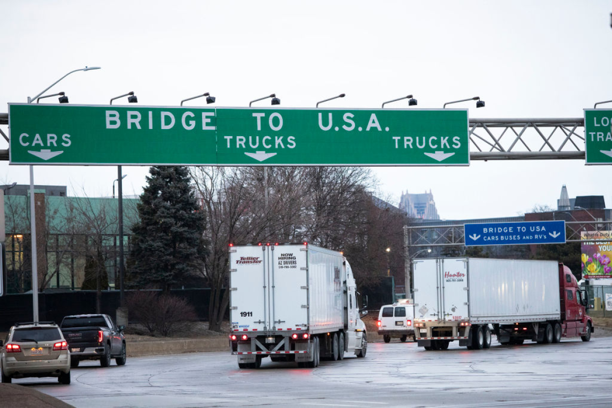 Trucks head to the Ambassador Bridge between Windsor, Canada and Detroit, Michigan on the first day of President Donald Trump's new tariffs on Canada, Mexico and China.