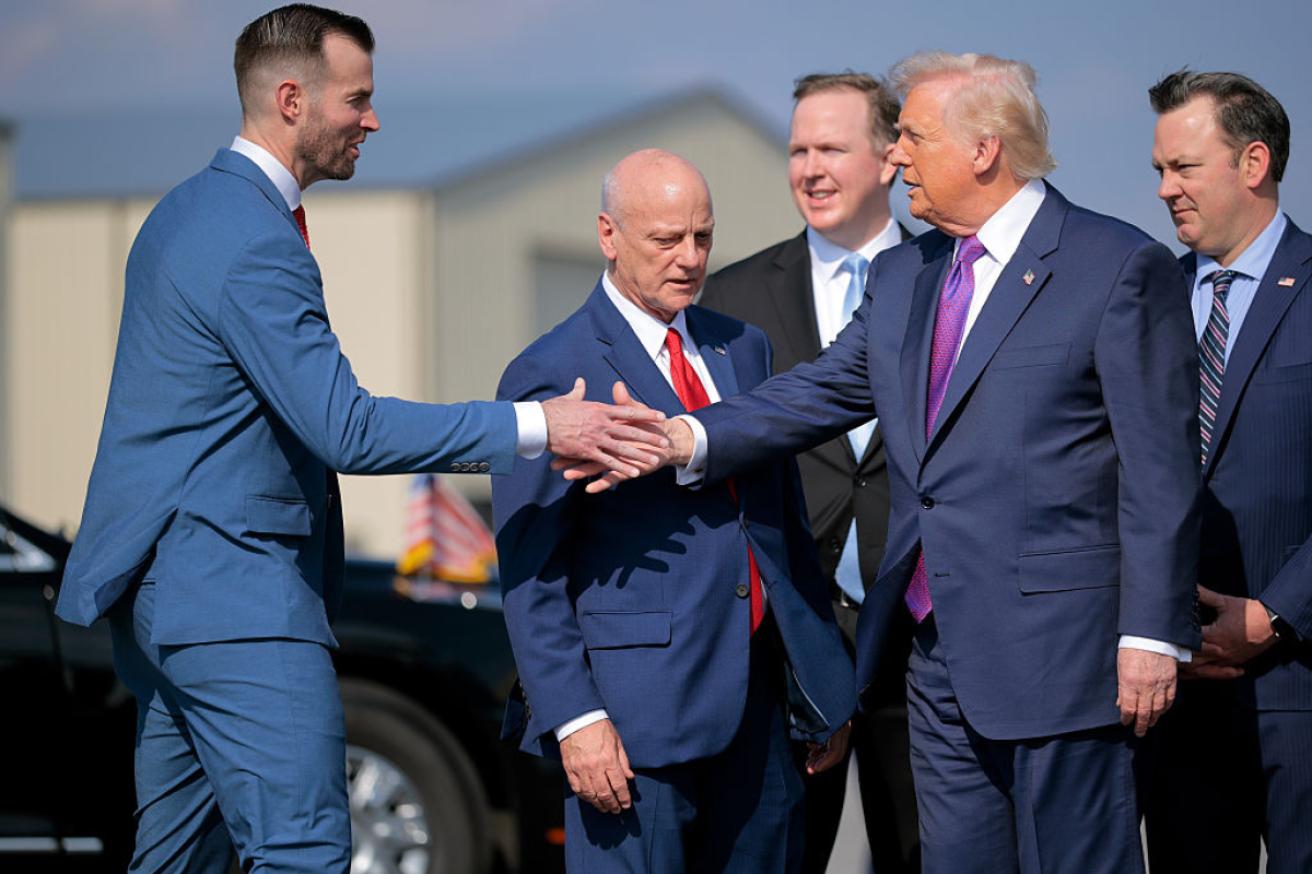 Republican congressional candidate Clay Fuller (left) shakes hands with President Trump as he arrives on Air Force One at Russell Regional Airport on Feb. 19 in Rome, Ga.