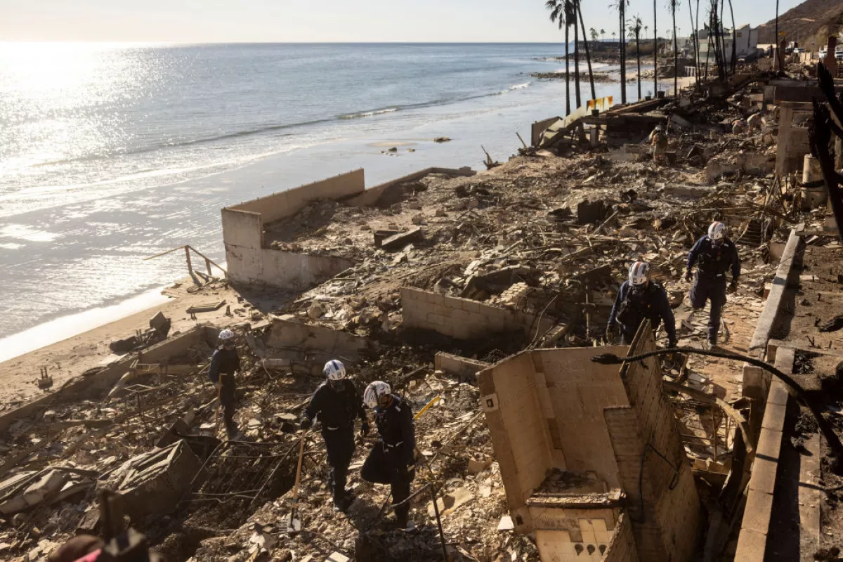 Members of California Task Force 3, one of 28 FEMA Urban Search and Rescue teams, comb through the ruins of a beachfront house where victims of the Los Angeles fires were reportedly buried, in January 2025.