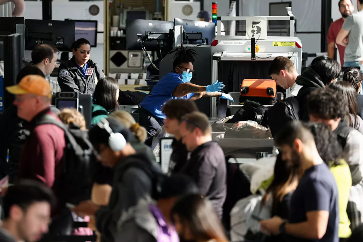 Passengers wait in line at a Transportation Security Administration checkpoint while traveling at Los Angeles International Airport in November 2025.