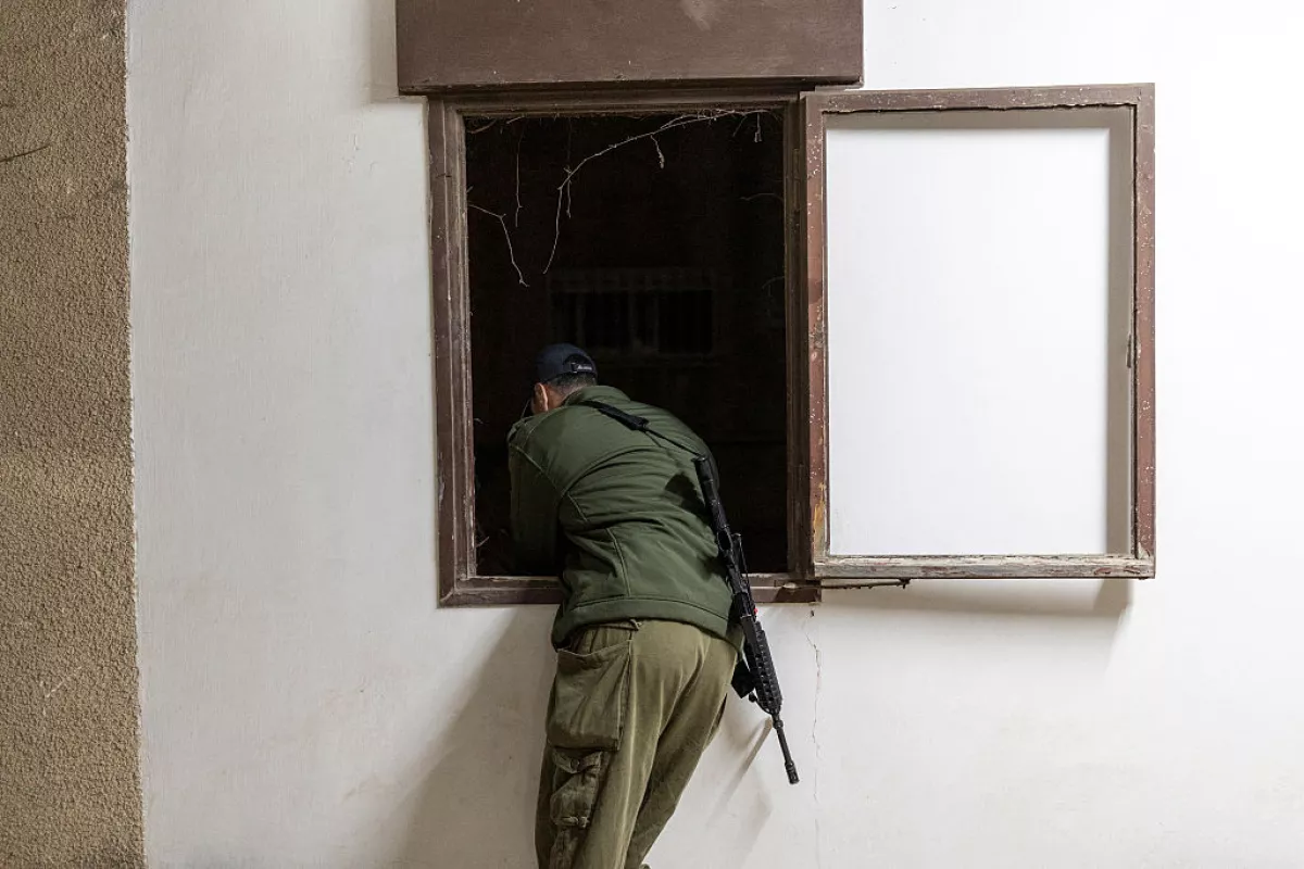 An Israeli soldier overlooks the scene as search and rescue personnel work at the site of a residential building destroyed in an Iranian strike in the northern city of Haifa on April 5, 2026.