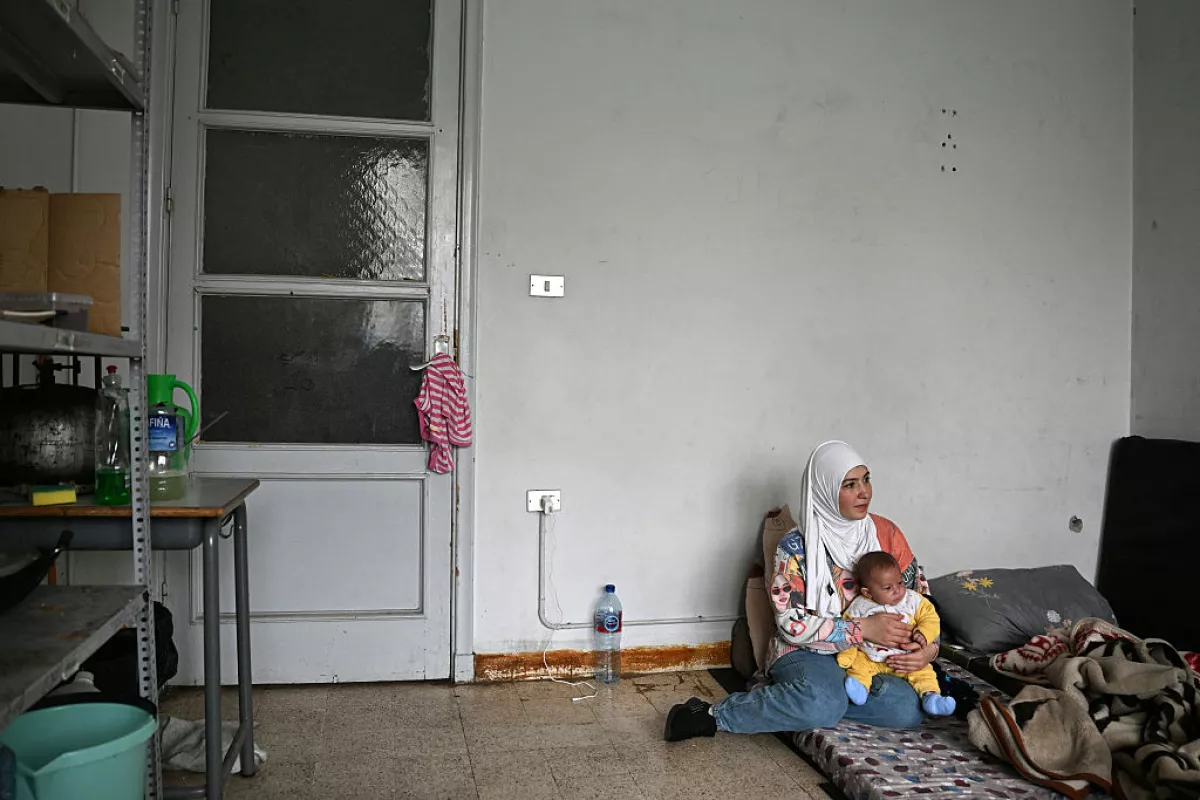 Lebanese displaced woman Mariam Zein sits with her son inside the classroom of a school transformed into a displaced reception center in the area of Dekwaneh, east of Beirut on April 15, 2026.