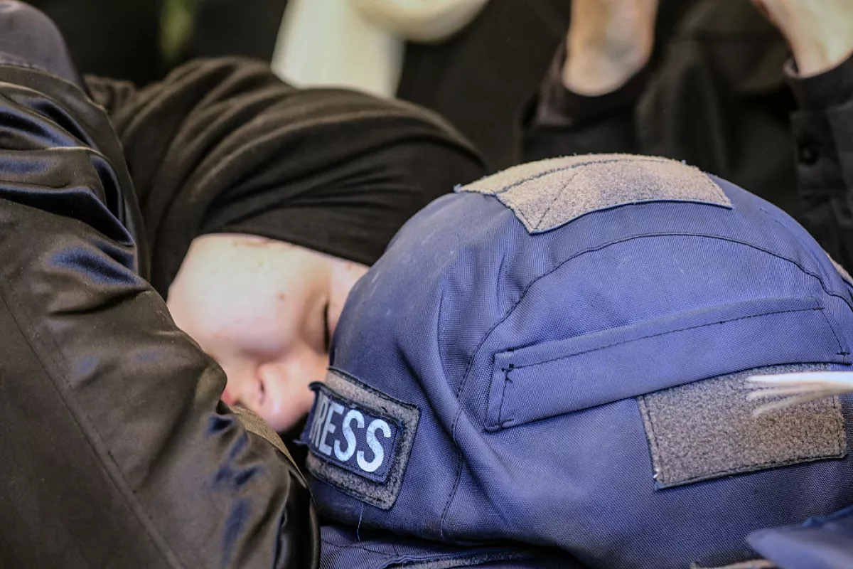 A woman mourns next to a press ballistic helmet as relatives and friends gather at the house of Amal Khalil, a veteran correspondent for the daily newspaper Al-Akhbar who was killed in a reported Israeli airstrike in southern Lebanon, in the village of Bisariyeh on April 23, 2026.