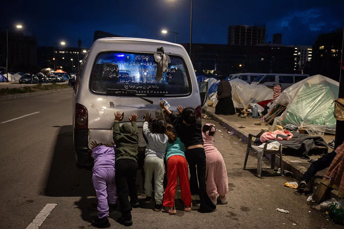 Displaced children help to push start the family's van at a temporary displacement camp near the Lebanon port on March 27, 2026 in Beirut, Lebanon.