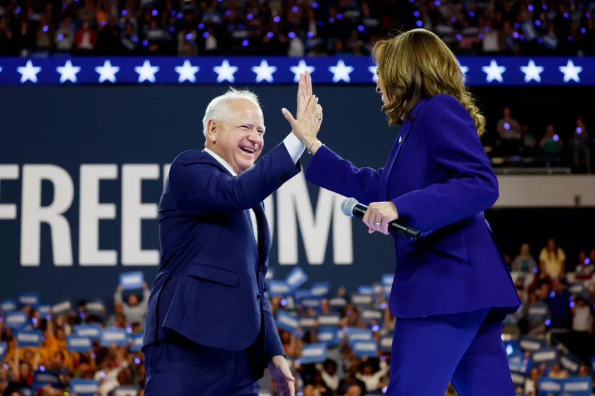 Democratic vice presidential candidate and Minnesota Gov. Tim Walz high-fives presidential nominee Kamala Harris at a campaign rally at the Fiserv Forum on Tuesday in Milwaukee.