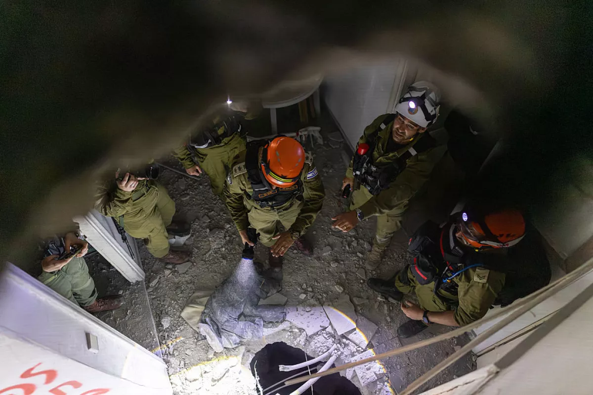 Members of Israel's Home Front Command (HFC) investigate a building damaged by a strike in Tel Aviv on March 28, 2026. On the evening of March 27, the Israeli army reported missiles fired by Iran at Israel.