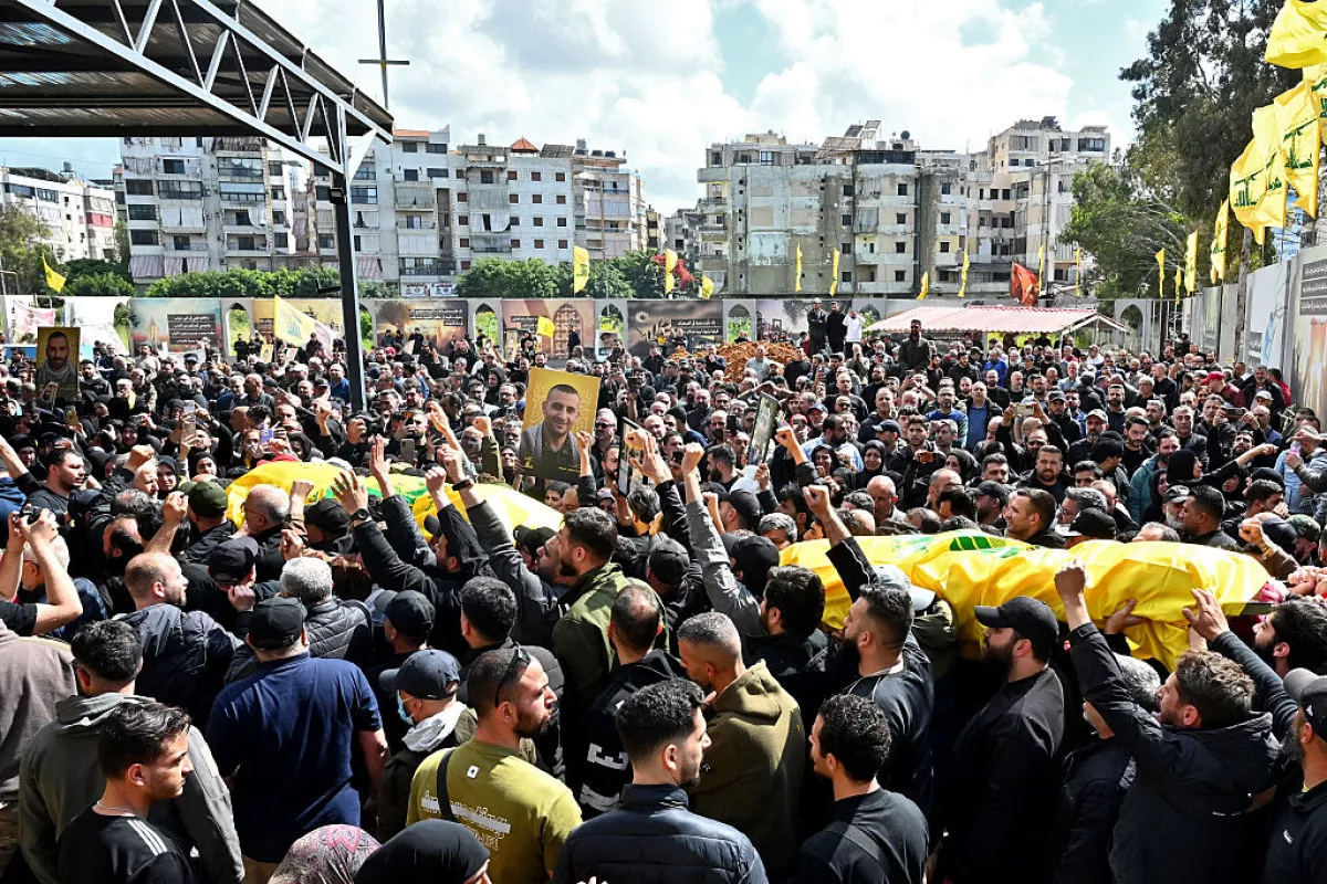 Mourners carry the flag-draped caskets of members of the Iran-backed militant group Hezbollah who were killed in southern Lebanon during their funeral in the Kafaat area in Beirut's southern suburbs on April 20, 2026.