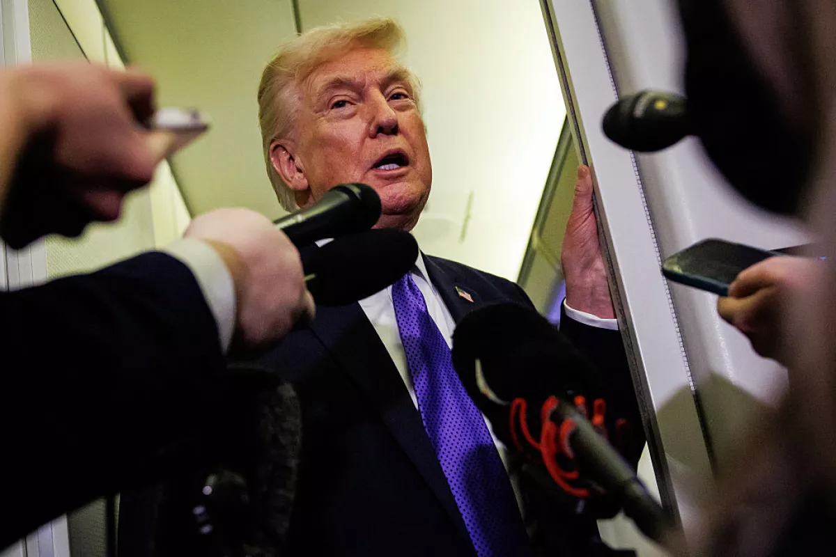 President Trump talks to reporters while aboard Air Force One on Friday en route to Palm Beach, Fla.