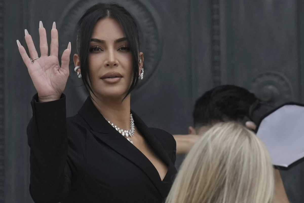 Kim Kardashian waves as she arrives Tuesday to testify regarding a robbery of millions of dollars in jewels from her Paris hotel room in 2016.