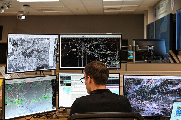 A Tropical analysis meteorologist works at his station at the National Oceanic and Atmospheric Administration's (NOAA) National Hurricane Center in Miami, Florida, on May 30, 2025. The administration of US President Donald Trump has fired hundreds of staff at the National Oceanic and Atmospheric Administration (NOAA) and deleted government websites with data on the weather and climate.