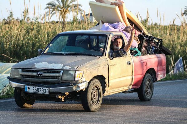 A man flashes the V-sign while driving a vehicle loaded with belongings through the al-Qassimyah area en route to southern Lebanon early on April 8, 2026, after the United States and Iran agreed to a two-week ceasefire. Israel renewed its strikes on southern Lebanon on April 8, state media reported, as the Israeli prime minister insisted the Iran war truce does not include Lebanon.