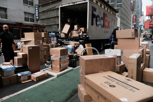 Dozens of packages are lined up along a Manhattan street as a FedEx truck makes deliveries on Dec. 6, 2021, in New York City.