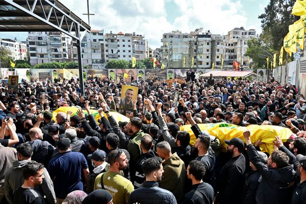 Mourners carry the flag-draped caskets of members of the Iran-backed militant group Hezbollah who were killed in southern Lebanon during their funeral in the Kafaat area, in Beirut's southern suburbs, on Monday.