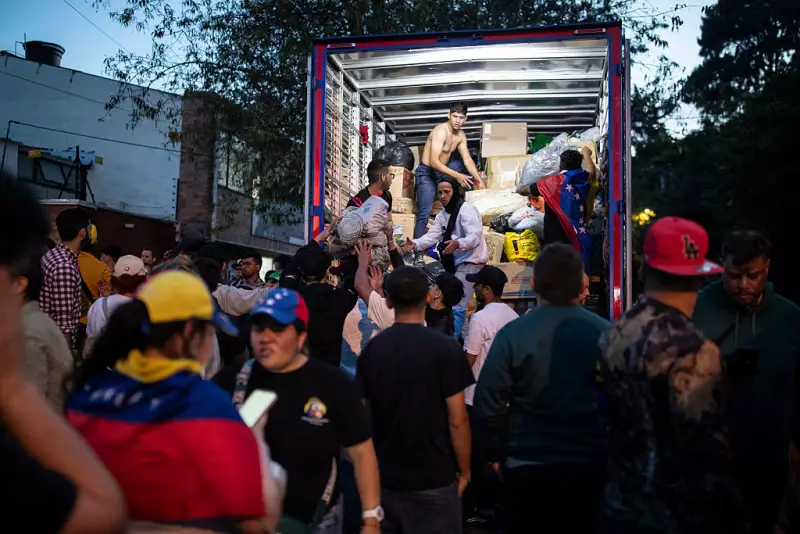 People unload donated supplies from a truck at a collection point in Bogota on June 26, 2026, as humanitarian aid to be sent to Venezuela following deadly earthquakes.